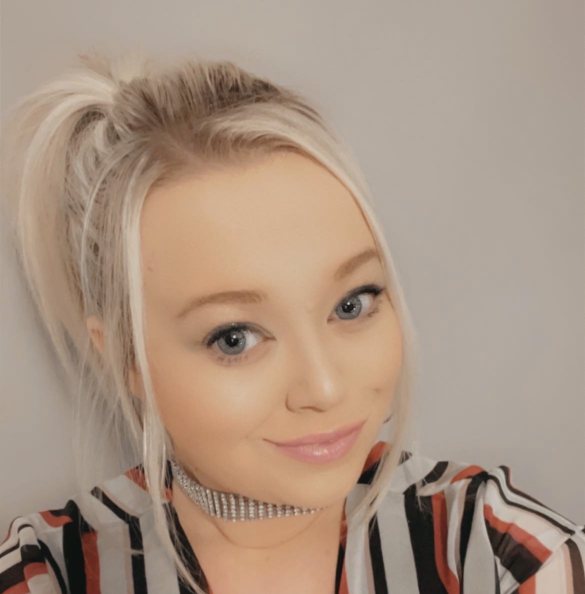 Ellie taking a selfie in a stripey top.