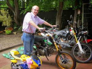 Derek in a checked shirt holding onto as motorcycle