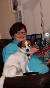 Anne in a blue jumper with a dog sitting in front of her