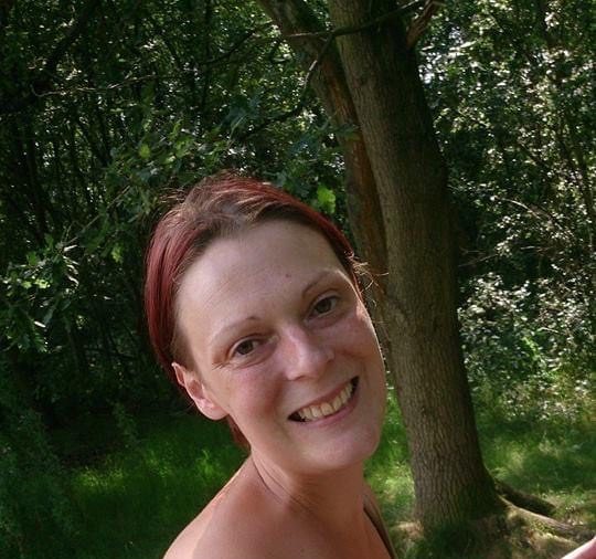 Sue smiling over her shoulder in a strapless blue top