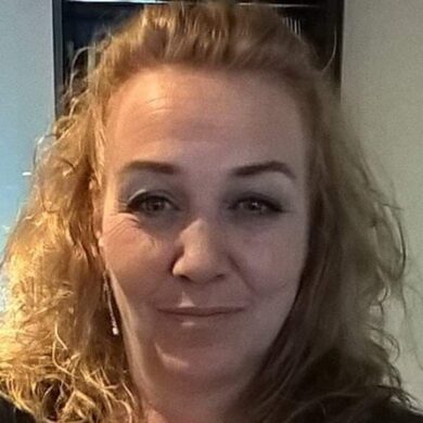 Lisa is taking a selfie. She has dark blonde shoulder-length hair and is smiling at the camera.