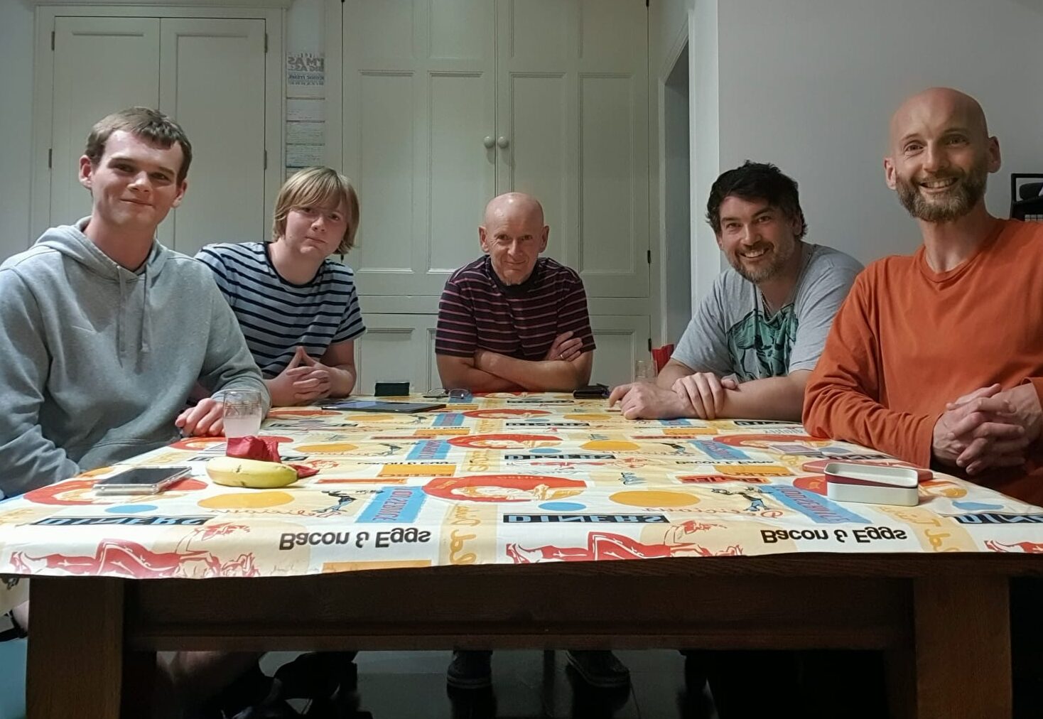 Jim and four family members sit smiling around a table