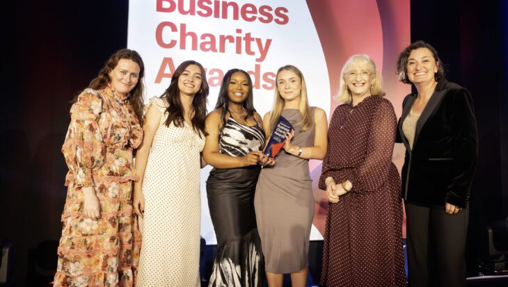 Team Guts UK are receiving an award at the Business Charity Awards on stage.