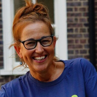 Suzanne is wearing a Guts UK t-shirt and smiling at the camera.