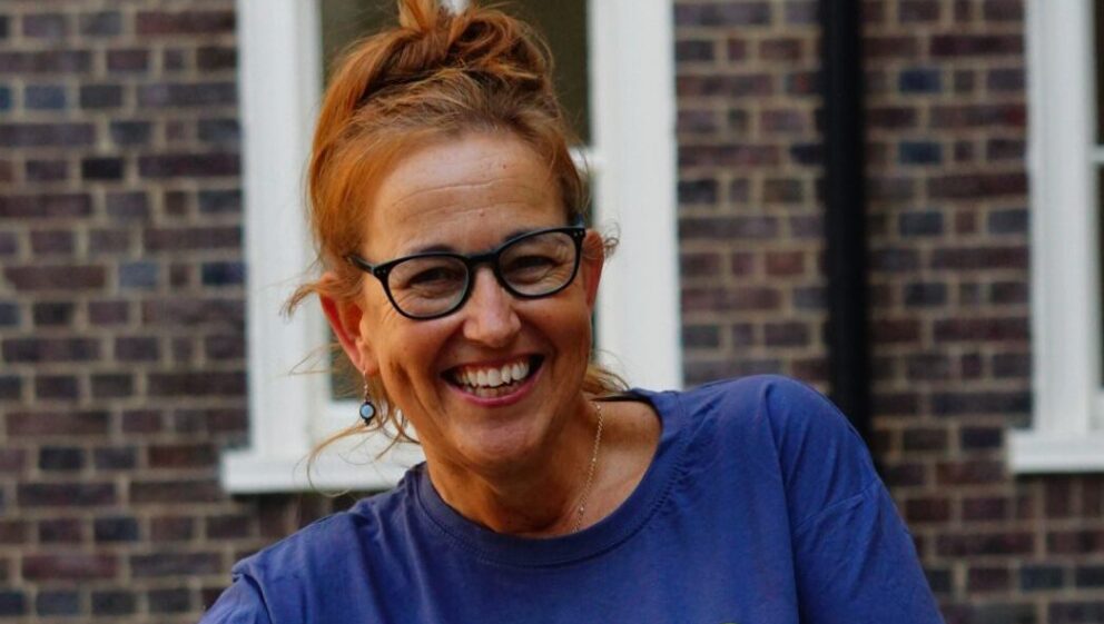 Suzanne is wearing a Guts UK t-shirt and smiling at the camera.