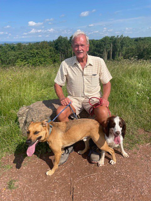 Tony takes a break on a walk with his daughter, Jen's, dogs Rocky and Molly