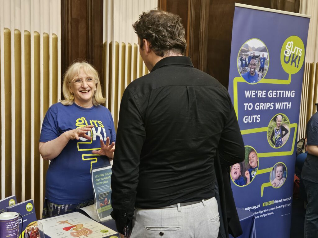 Julie Thompson, Information Manager at Guts UK, speaks to a member of the public at an event.