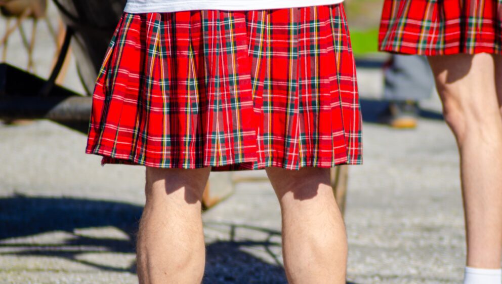 A person wearing a bright red tartan kilt