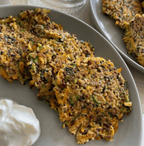 A trio of quinoa fitters on a plate, with a dollop of mayonnaise.
