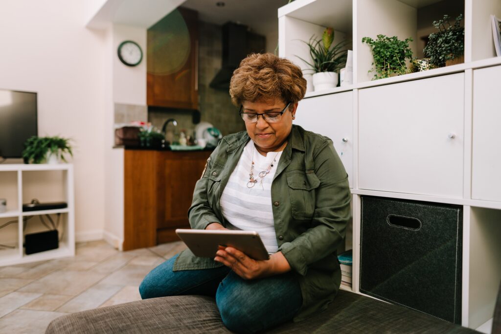 A woman is sat looking on her tablet device