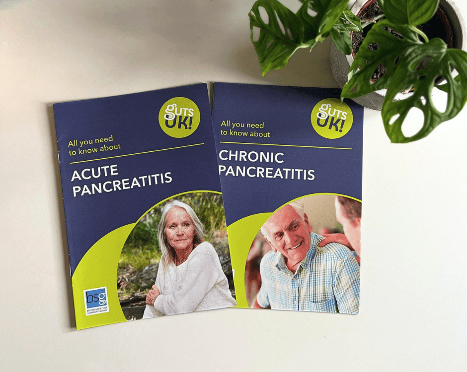 Acute pancreatitis and chronic pancreatitis Guts UK information leaflets, on a white table, with a green, luscious cheese plant in the top right hand corner, from a bird's eye view.