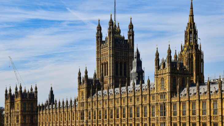 A photo of the Houses of Parliament, with a blue sky with wispy clouds.