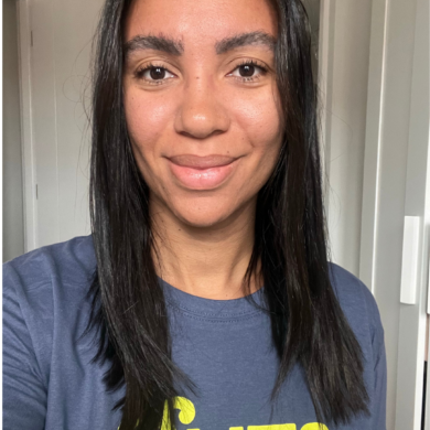 Jen smiles, taking a selfie in a Guts UK t-shirt.