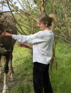 A young woman petting a horse